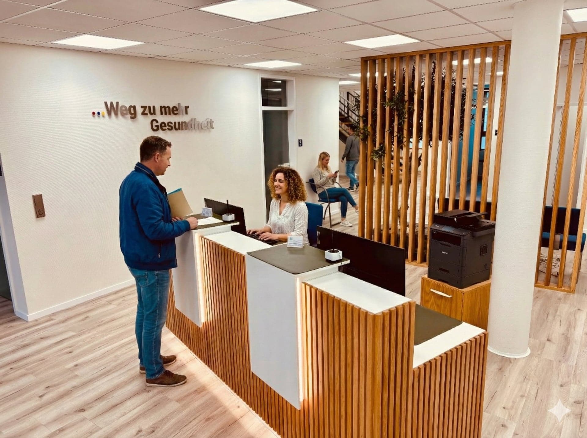 Moderner Empfangsbereich mit Holzlamellen und Schriftzug Weg zu mehr Gesundheit in der KG Praxis Berkemeyer Garrel