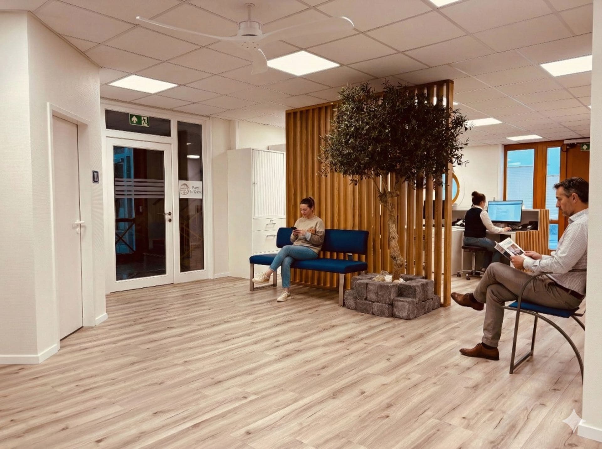 Heller Wartebereich mit bequemen Sitzgelegenheiten und dekorativen Holzlamellen in der KG Praxis Berkemeyer